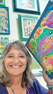 Robbin Robertson with her painting at Moon Over Water gallery in Rockport, Texas
