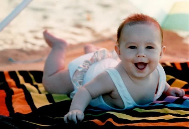 Smiling baby on colorful beach towel