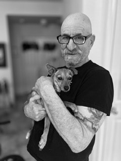 Black and white portrait of a man holding a small dog