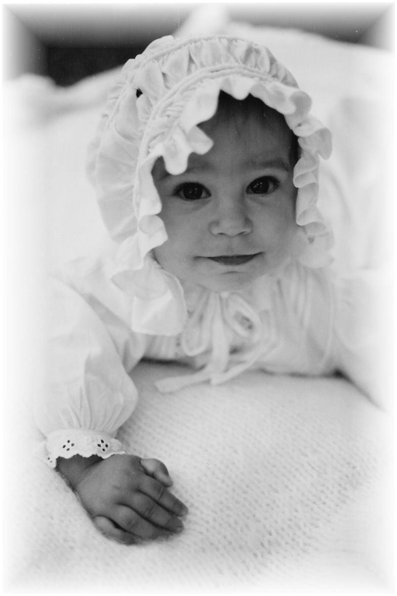 Black and white portrait of infant in vintage bonnet