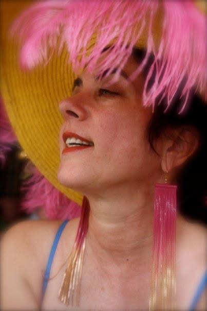 Color portrait of woman with pink feathered hat and long earrings