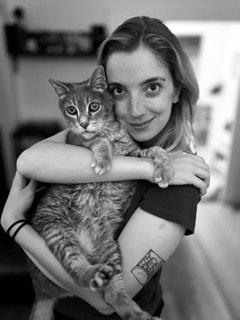 Black and white portrait of young woman holding a cat
