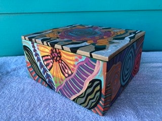 Colorful abstract painted wooden box with bold stripes and patterns